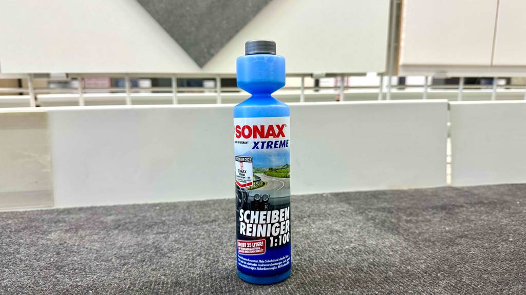 Im Test: Scheibenreiniger-Konzentrat 1:100 in der Flasche von Sonax steht auf einem Grauen Teppichboden.