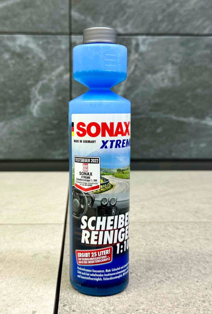 Das getestete Scheibenreiniger-Konzentrat 1:100 in der Flasche von Sonax steht auf einem Bodenbelag.