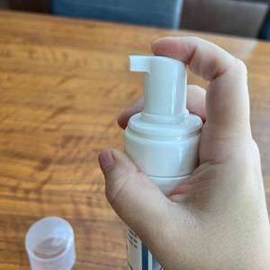Eine Hand drückt auf den Sonax XTREME Polsterreiniger.