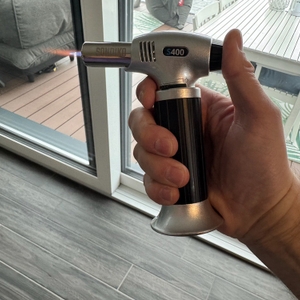 Eine Hand erzeugt mit dem Sondiko-Küchenbrenner S400 eine schwache Flamme