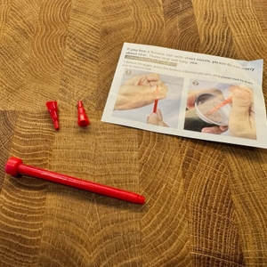 Verschiedene Adapter zu verschiedenen Butangasflaschen liegen neben der Anleitung zur Anwendung