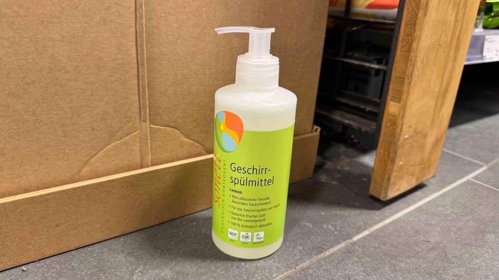 Vor einem Karton steht ein Sonett-Geschirrspülmittel im Test auf dem Boden.