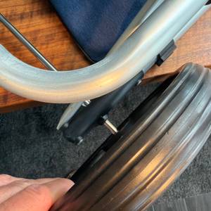 Ein Reifen wird auf die Achse des Songmics KST02GY geschoben.