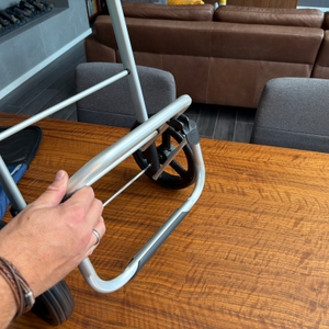 Eine Hand klappt das Gestell des Songmics KST02GY aus.