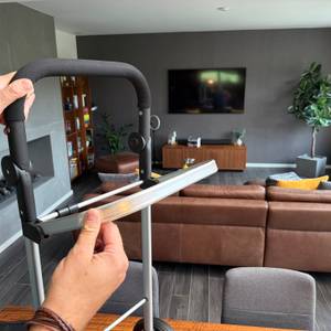 Eine Hand befestigt einen Teil des Gestells vom Songmics KST02GY.