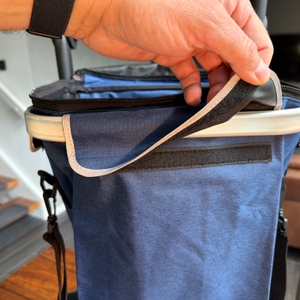 Eine Hand öffnet den Verschluss des Songmics KST02GY.