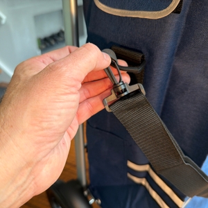 Eine Hand befestigt eine Trageschlaufe am Songmics KST02GY.