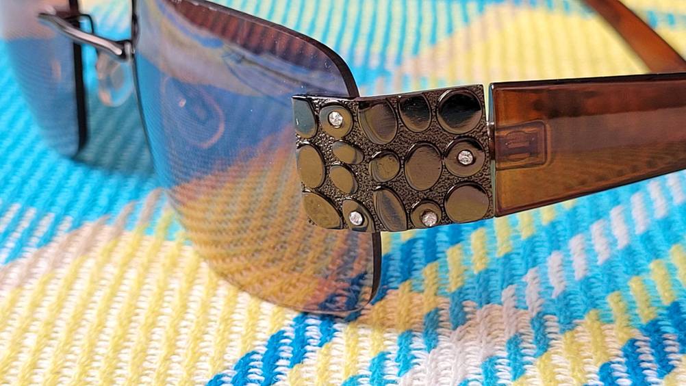 Nahaufnahme einer Sonnenbrille auf einem Strandtuch