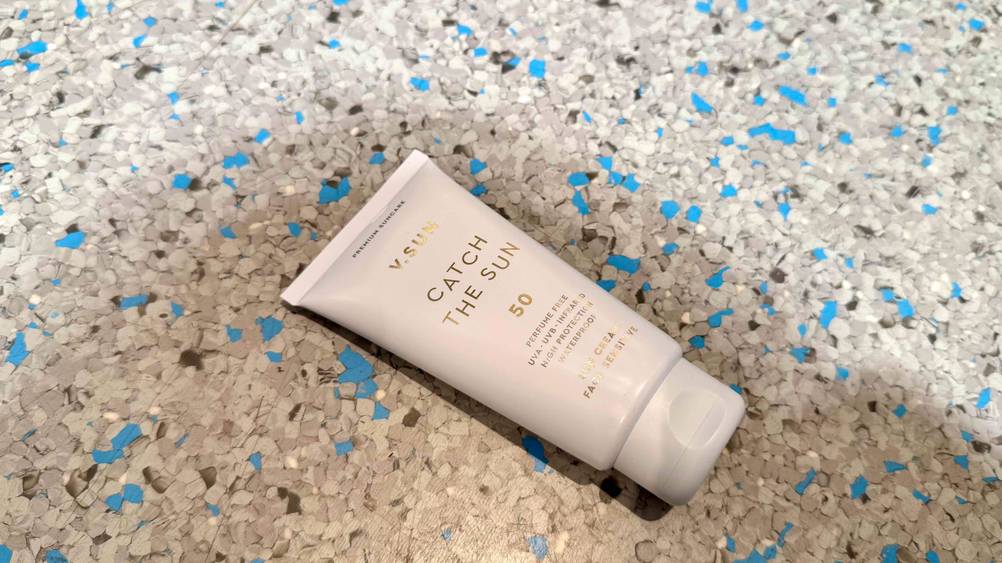 Auf einem grau-blauen Boden liegt leicht horizontal eine Tube der Sonnencreme Gesicht 50 im Test.