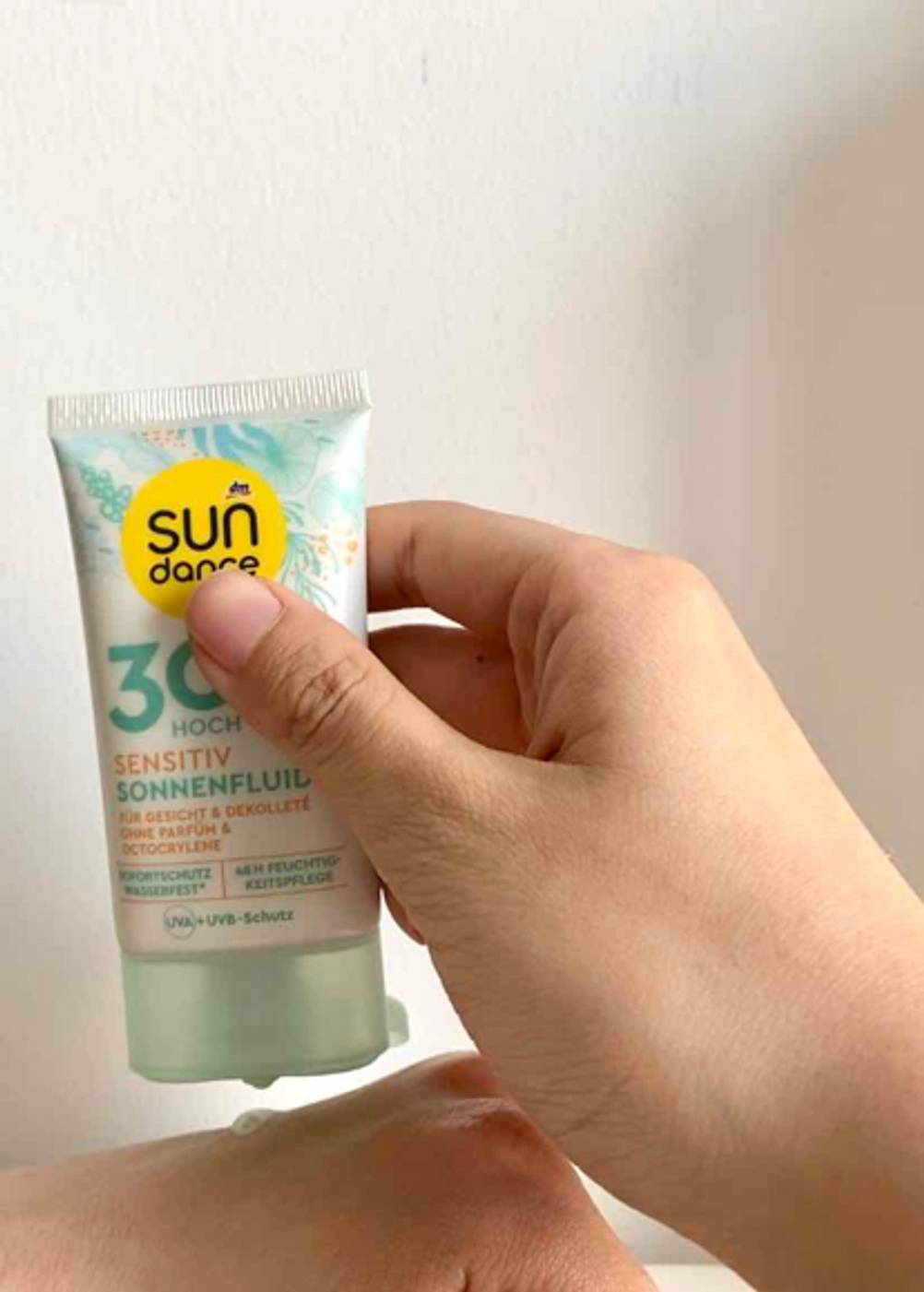 Eine getestete Sonnencreme für das Gesicht wird auf dem Handrücken aufgetragen.