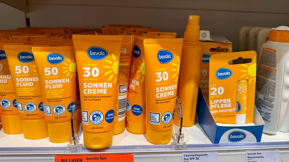 Mehrere Tuben der getesteten Sonnencreme mit LSF 30 stehen in einem Regal mit anderen Produkten.