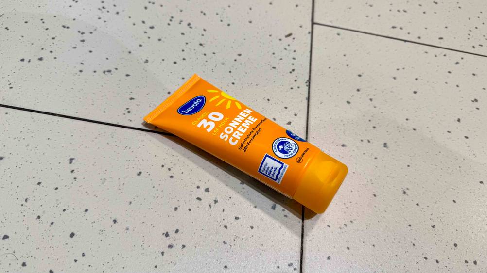 Getestet: Eine Tube Sonnencreme mit LSF 30 liegt horizontal auf einem hellen Boden.