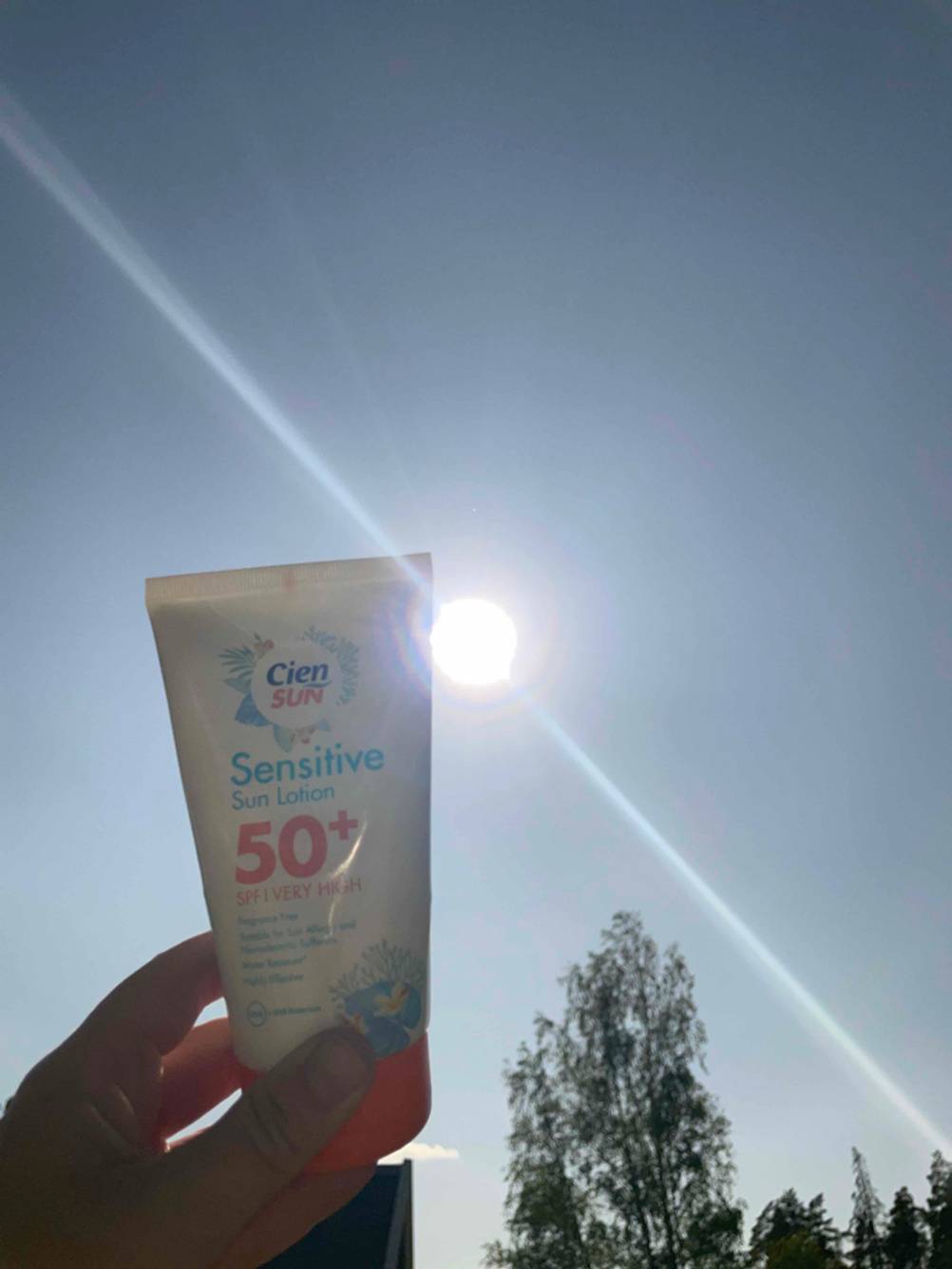 Eine Hand hält eine getestete Sonnencreme mit LSF 50.