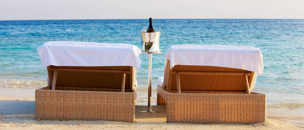 Loungers At Edge Of Tropical Sea With Champagne Bucket