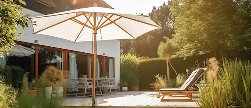 Holz-Sonnenschirm-Test: Ein heller Sonnenschirm steht vor einer großen Terrasse.