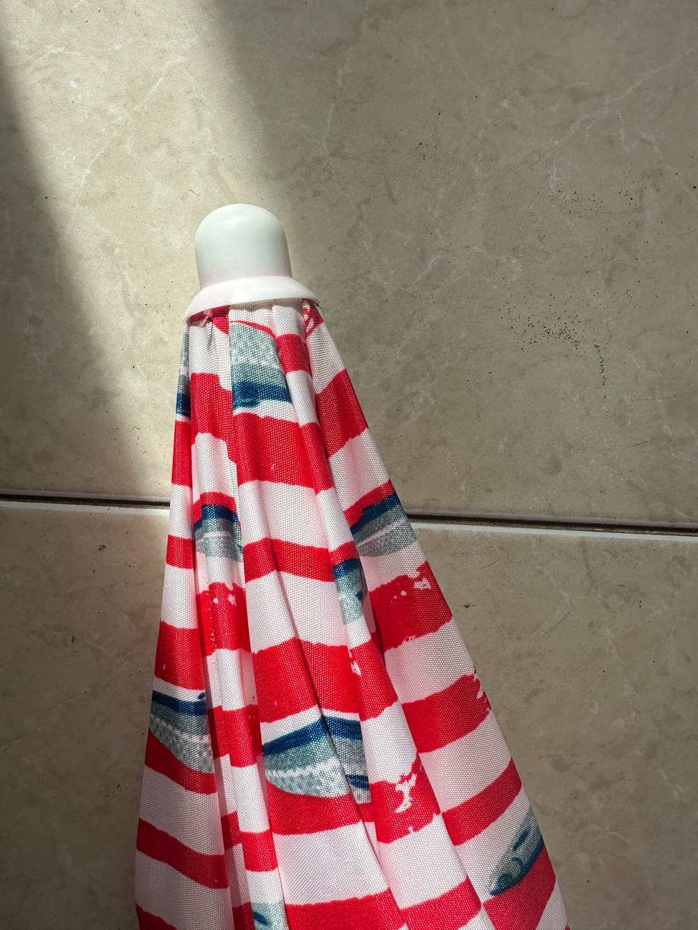 Detailansicht des oberen Teils mit Kappe eines getesteten Sonnenschirms für den Strand.