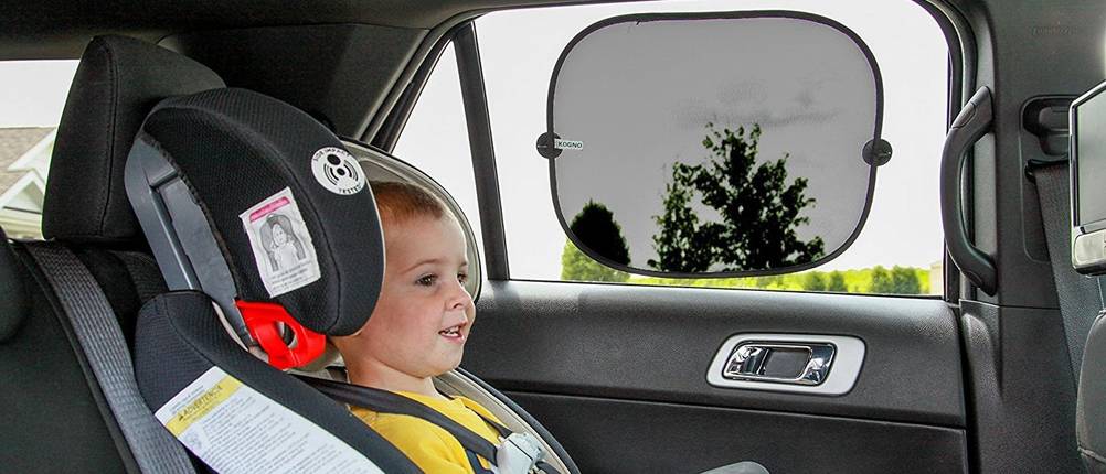 Auto-Sonnenschutz im Test: Kind im Kindersitz auf der Rückbank, eine Sonnenblende an der Fensterscheibe.