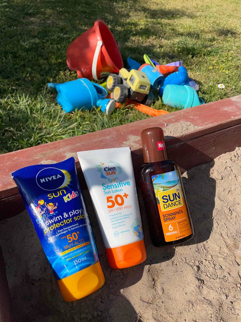 verschiedenen Sonnenschutzmittel im Sand