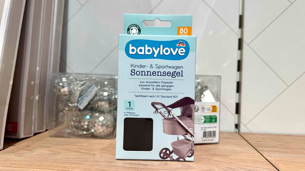 Getestet: Ein Sonnensegeln für Kinderwagen steht auf einem Holzregal.