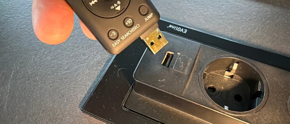 Eine Hand steckt den Anschluss vom Sony ICD-UX570B ein