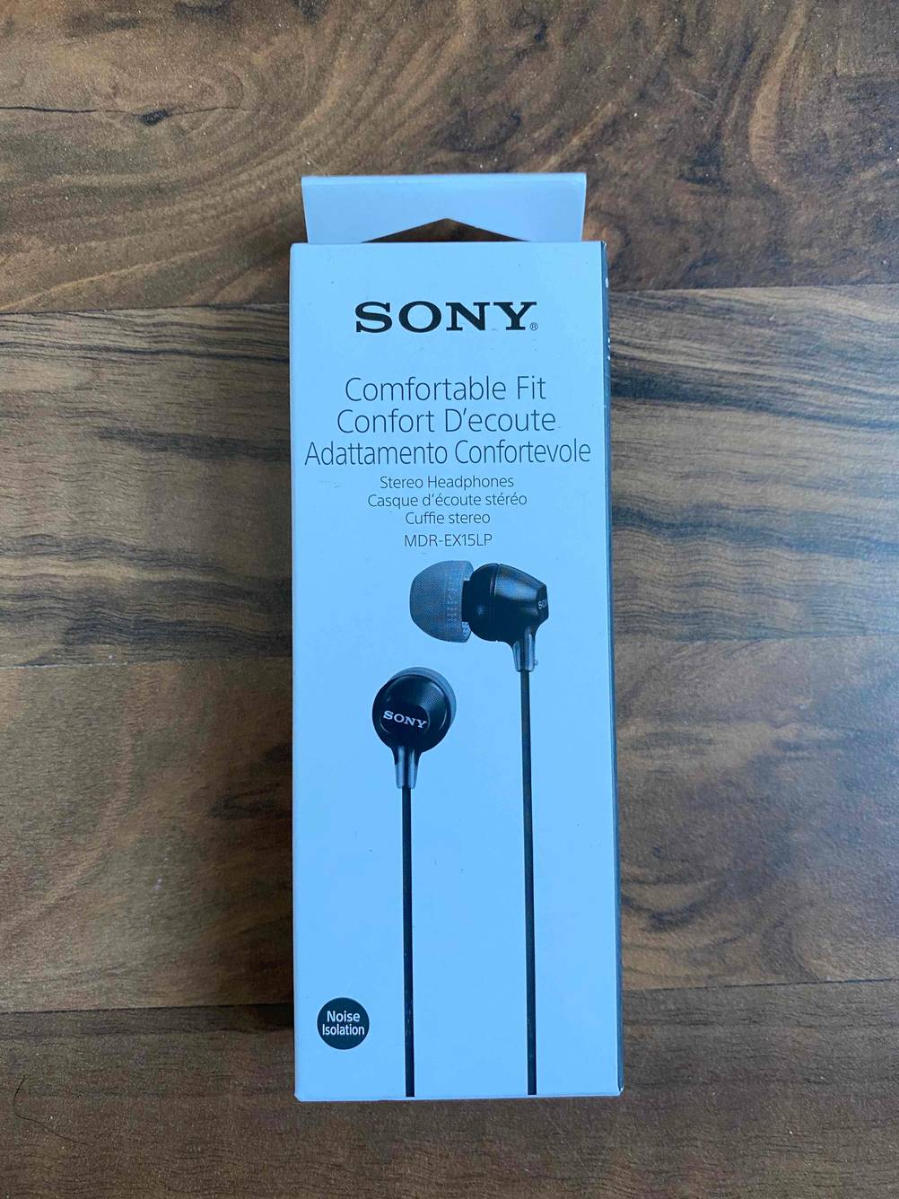 Die originalverpackten Sony-Kopfhörer im Test auf einer Holzfläche.