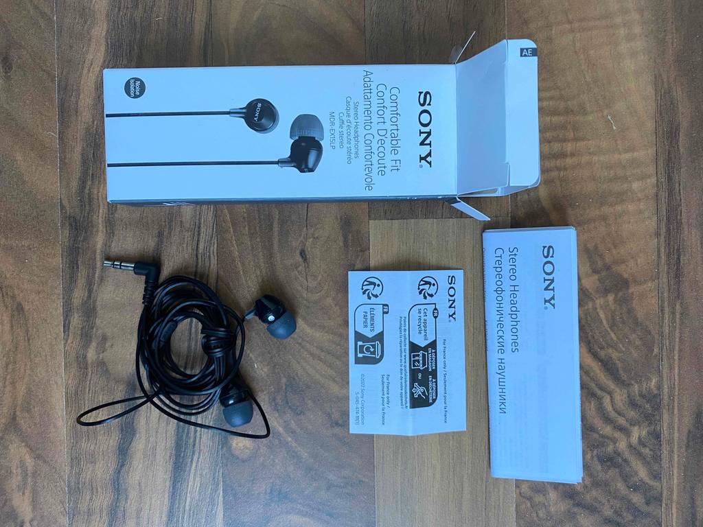 In-Ear Sony-Kopfhörer im Test liegen ausgepackt neben ihrer Originalverpackung und einer Gebrauchsanleitung.