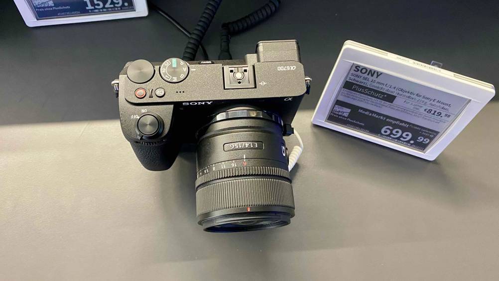 Sony-Systemkamera getestet: Ein Gerät von oben mit Bedienelementen und Informationen zum Objektiv, daneben die Preisangaben.