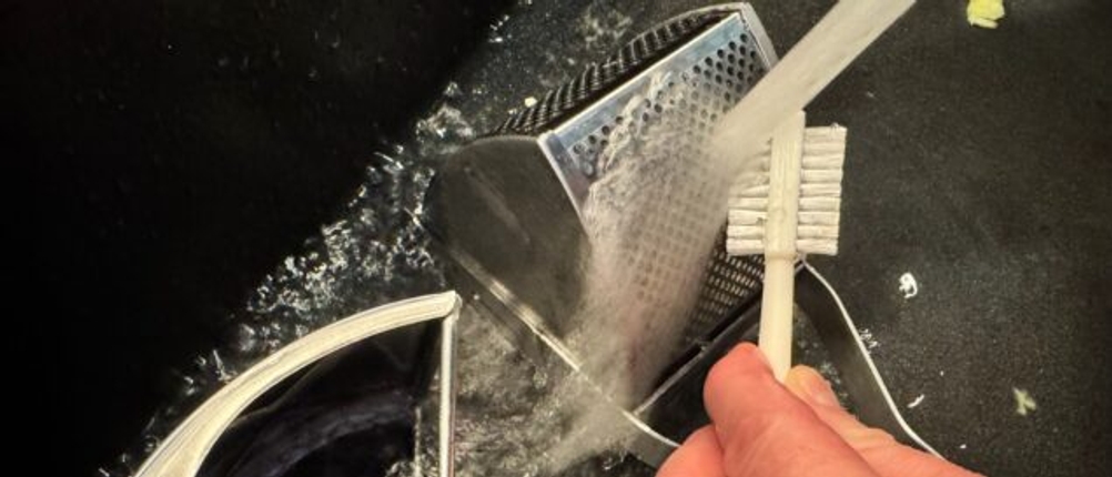 Reinigung der Sopito-Kartoffelpresse mit einer Reinigungsbürste.