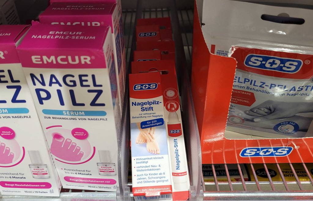 Nagelpilzlack im Test: Mehrere Packungen von unterschiedlichen Herstellern liegen in einem Regal.