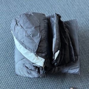 Zusammengefalteter Soulout Schlafsack 4-Jahreszeiten liegt auf Teppich