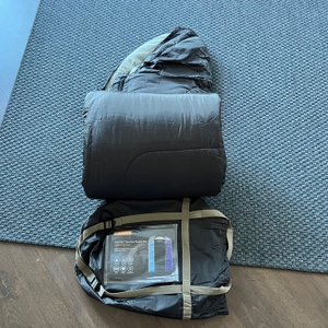 Soulout Schlafsack 4-Jahreszeiten liegt zusammen mit entfernter Hülle auf Teppich