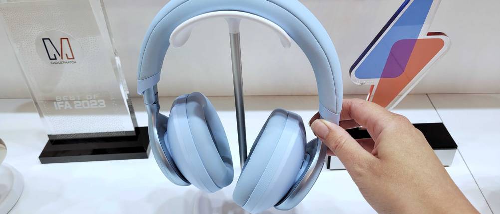 Noise-Cancelling-Kopfhörer im Test: eine Hand nimmt einen hellblauen Kopfhörer von einem Verkaufsständer