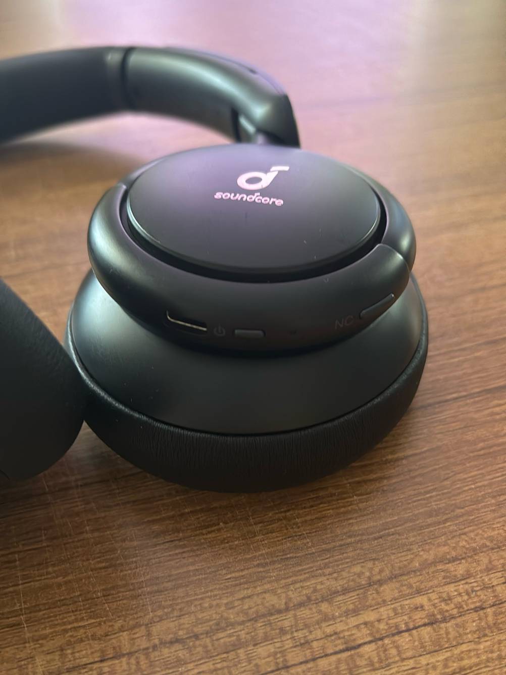 DJ-Kopfhörer im Test: Detailansicht eines Hörers mit Ladekabelanschluss, Powertaste und Einstellungstaste.