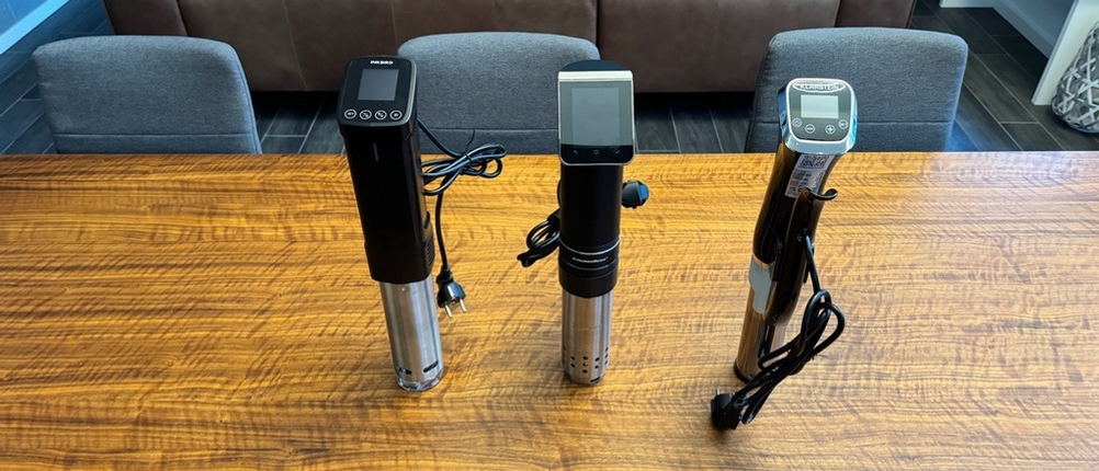 Drei Sous-Vide-Sticks stehen nebeneinander auf einem Tisch