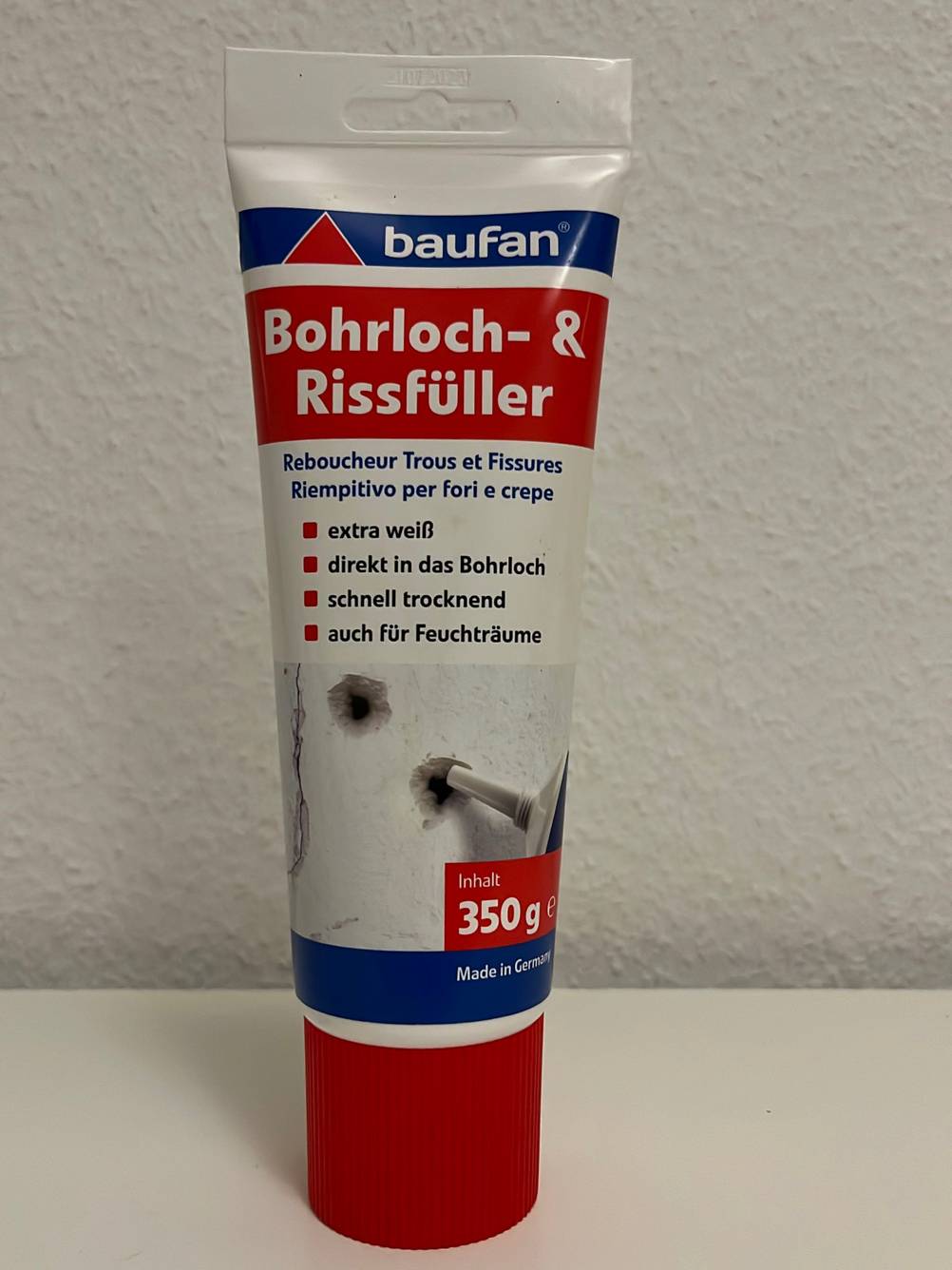 Getestete Spachtelmasse von Baufan steht vor einer weißen Wand.