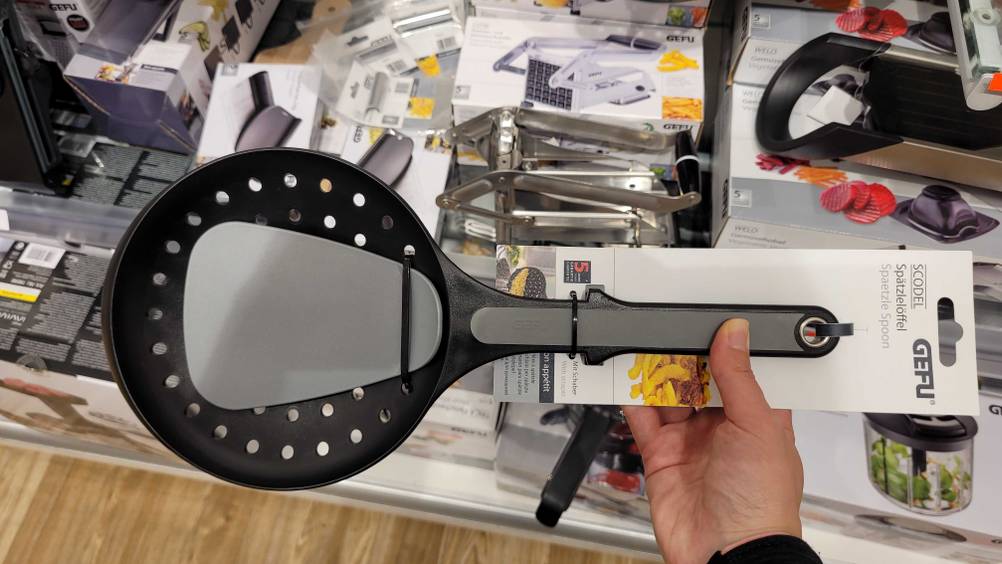 Eine Hand hält das getestete Spätzlesieb hoch.