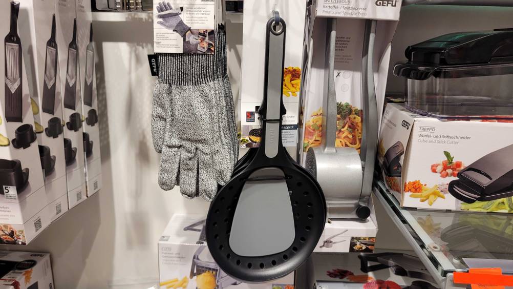 Ein getestetes Spätzlesieb hängt neben anderen Produkten in einem Verkaufsregal.