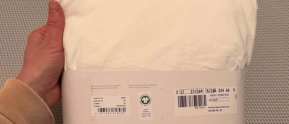 Spannbettlaken 200x200 im Test: Häufig sind Spannbettlaken nur noch mit einer Papp-Manschette verpackt.