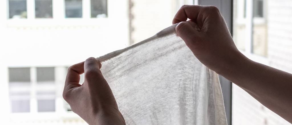 Ein Spannbettlaken wird gegen das Licht gehalten.