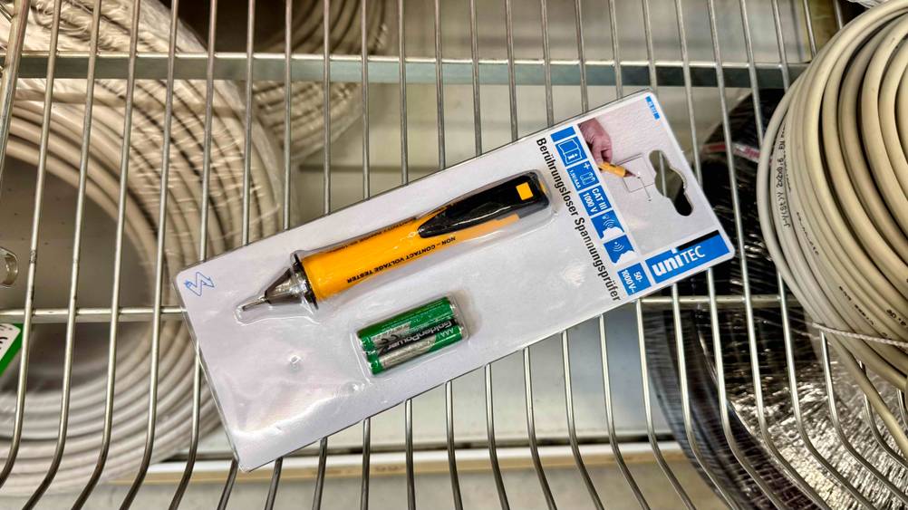 Auf einem Gitter liegt der verpackte Spannungsprüfer (berührungslos) im Test.