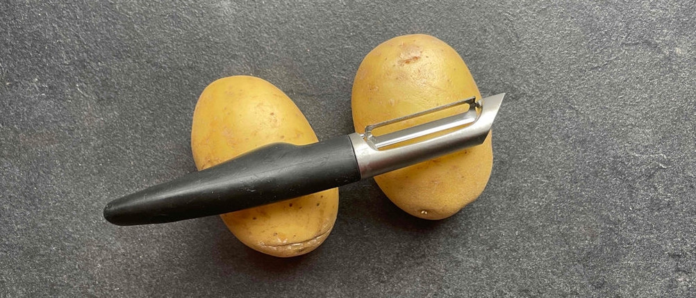 Sparschäler auf zwei Kartoffeln von oben.