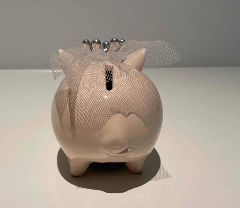 Ein getestetes Braut-Sparschwein von hinten auf einer hellen Fläche.