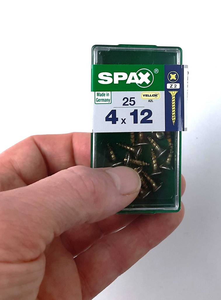 Im Test: Eine Hand hält eine Box mit Spax-Schrauben der Größe 4x12.