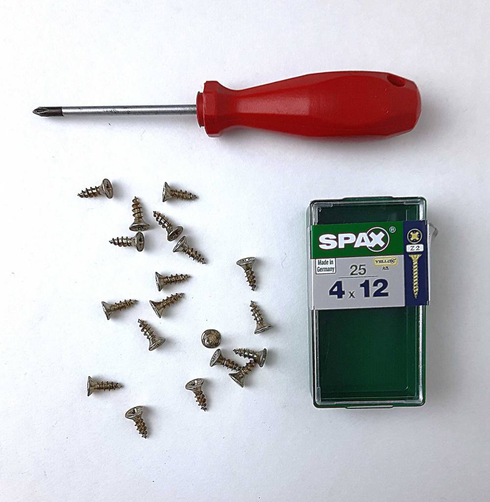 Über Spax-Schrauben im Test liegt ein Schraubenzieher, daneben die Aufbewahrungsbox.