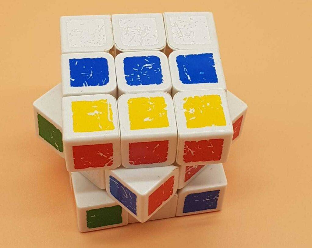 Nahaufnahme von einem getesteten Speedcube, der sich vor einem pfirsichfarbenen Hintergrund befindet und mehrere Farben in einer Reihe aufweist.
