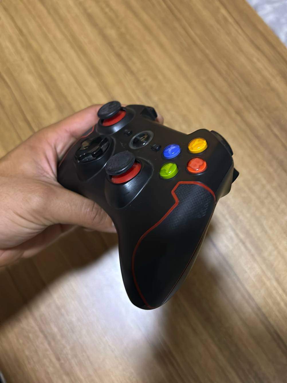 Im Test: Eine Hand zeigt einen Android-Controller in der schrägen Seitenansicht.