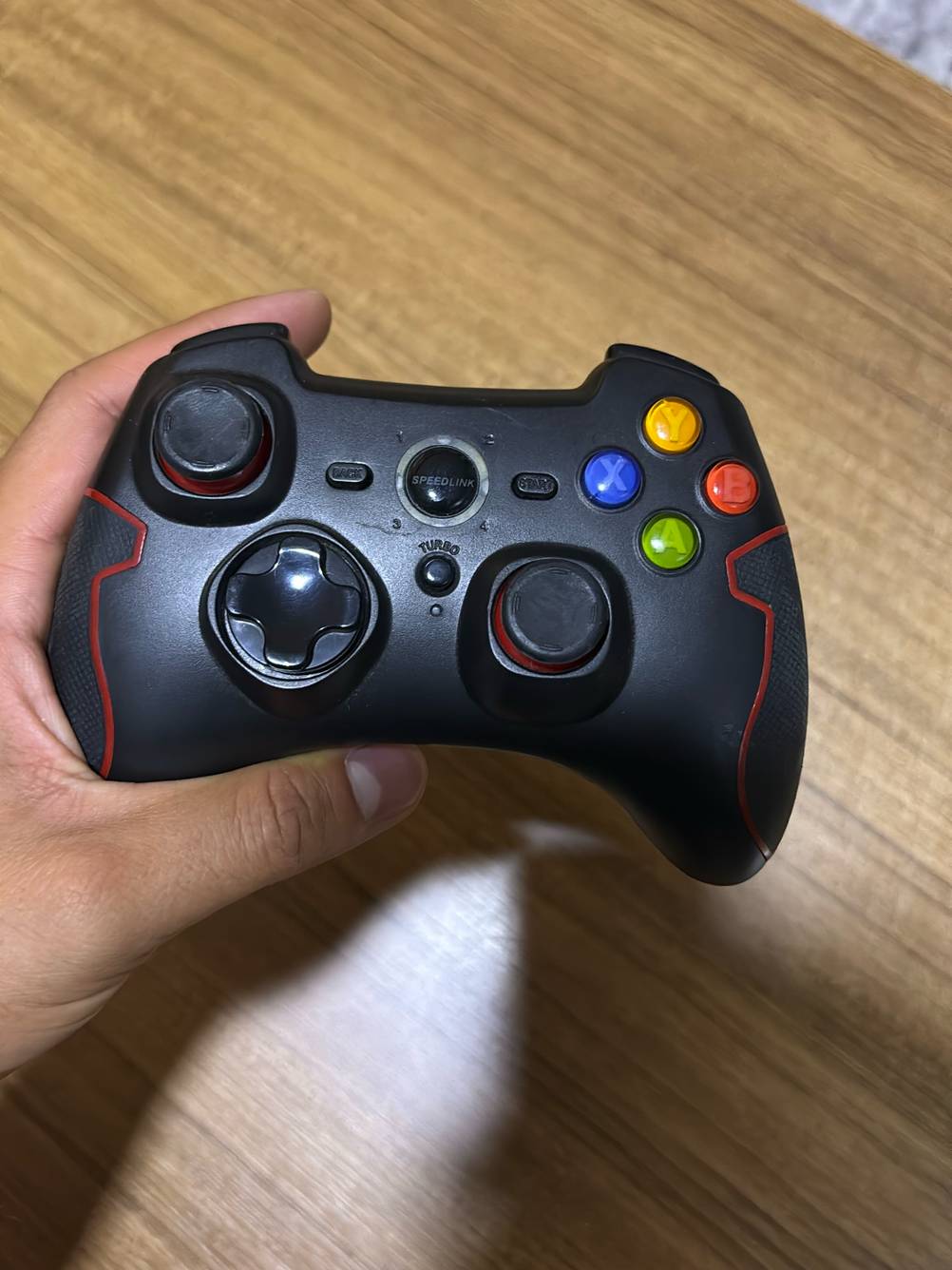Frontansicht eines getesteten Android-Controllers, der von einer Hand gehalten wird.