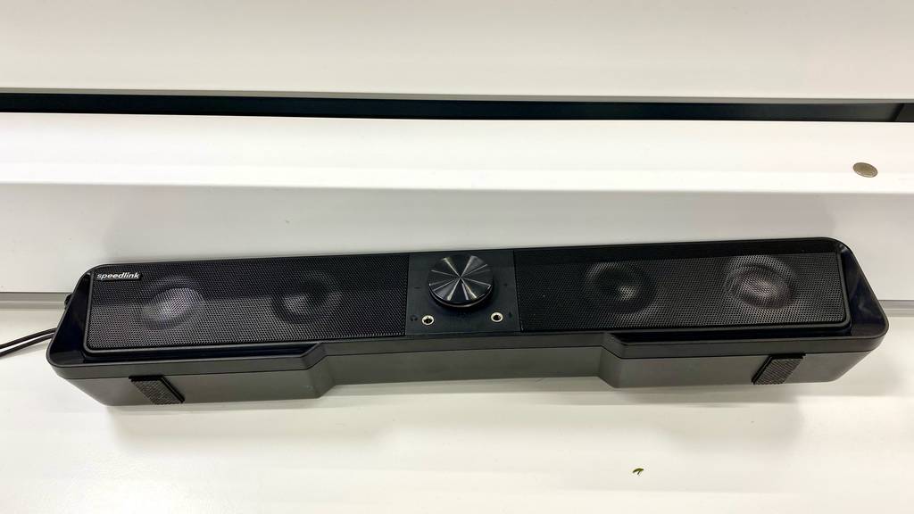 Eine getestete Bluetooth-Soundbar von oben mit Lautsprechern und Bedienelementen auf einer hellen Fläche.