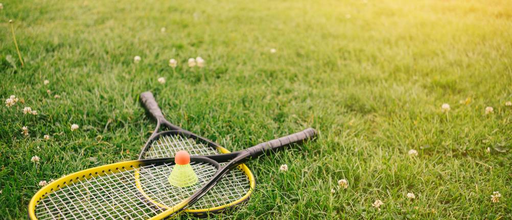 Speedminton-Test: Ein Speedminton-Set aus zwei Schlägern und einem Ball liegt auf einer Wiese.
