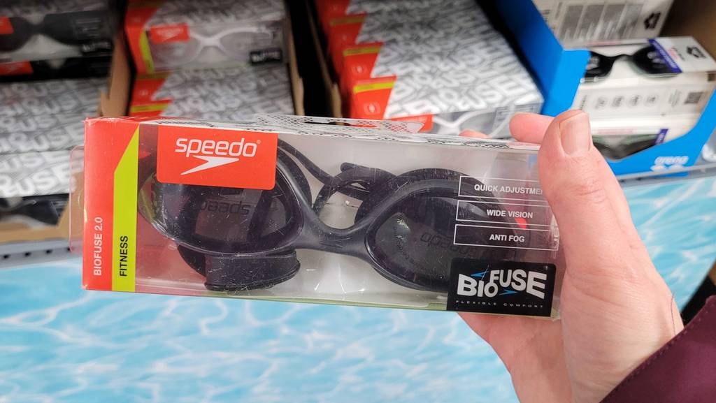 Schwimmbrille-Test: Hand hält eine Speedo Biofuse Schwimmbrille im Test, die sich in einer transparenten Kunststoffpackung befindet.